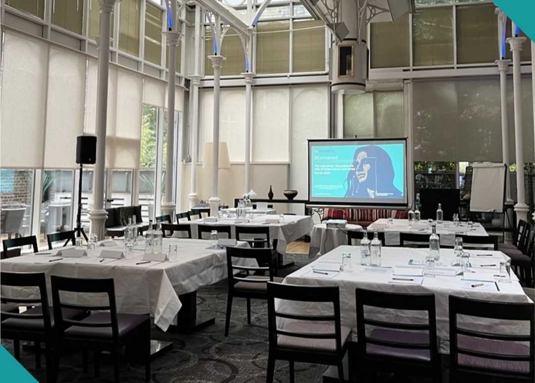 meeting room with laid out tables and a projector screen